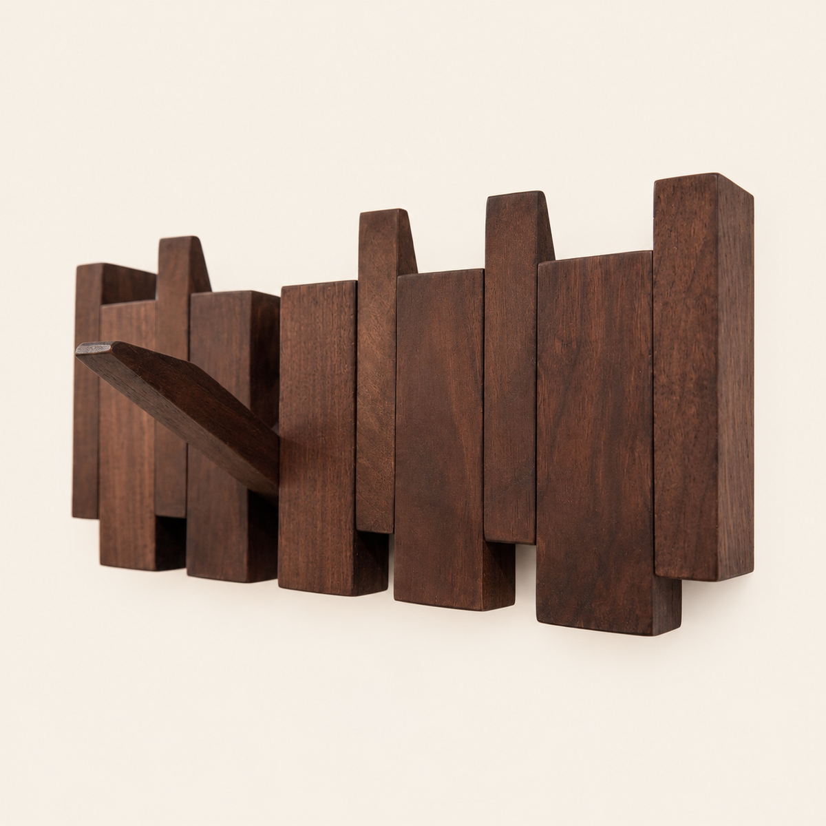 The Piano Hook in natural walnut, shown from an angle with one hook folded down — Wood Store NZ