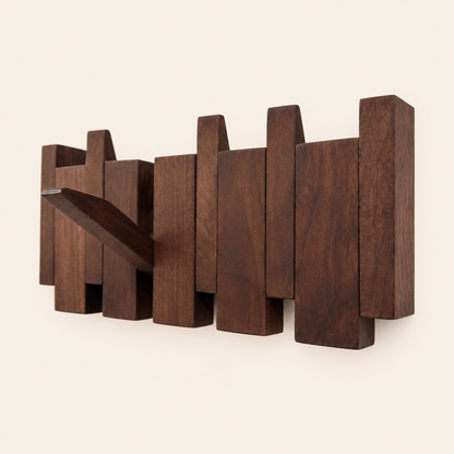 The Piano Hook in natural walnut, shown from an angle with one hook folded down — Wood Store NZ
