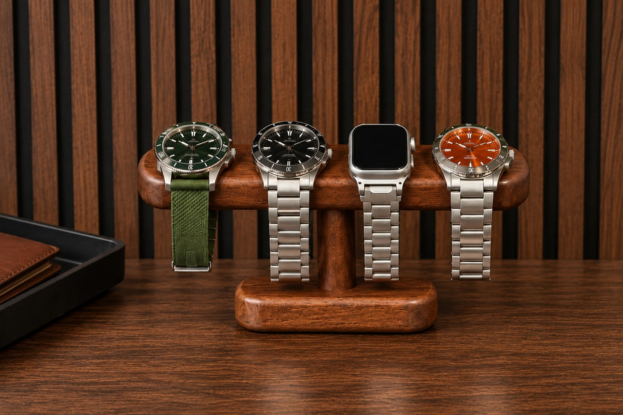 Four watches displayed on a solid timber T-bar stand