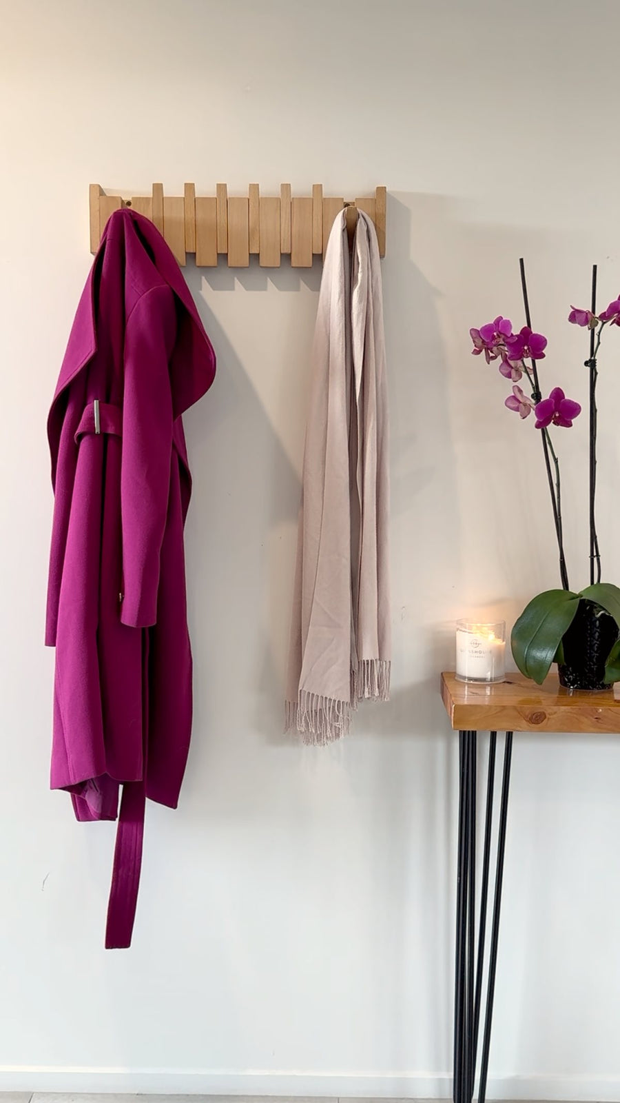 The Piano Hook in solid timber holding a coat and a scarf in a hallway