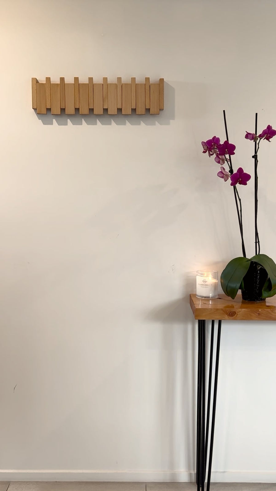 The Piano Hook with every key lifted flush, flat against a bare hallway wall