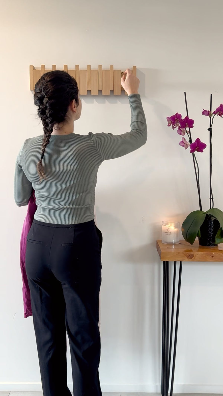 A hand pulling one timber key down on the Piano Hook rack